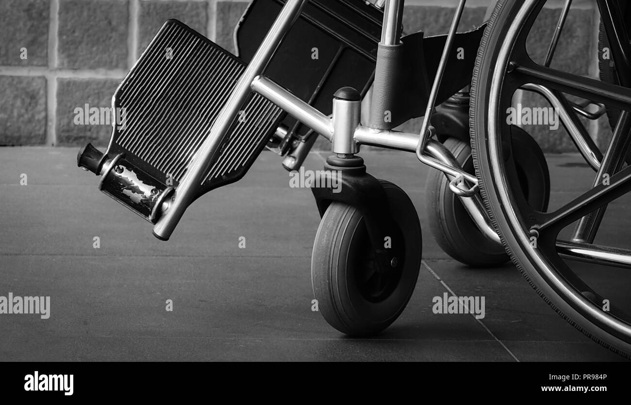 Closeup foot rest and whee of wheelchair. Sad news at the hospital. Depression with aging society. Lonely empty wheelchair. Medical equipment for serv Stock Photo