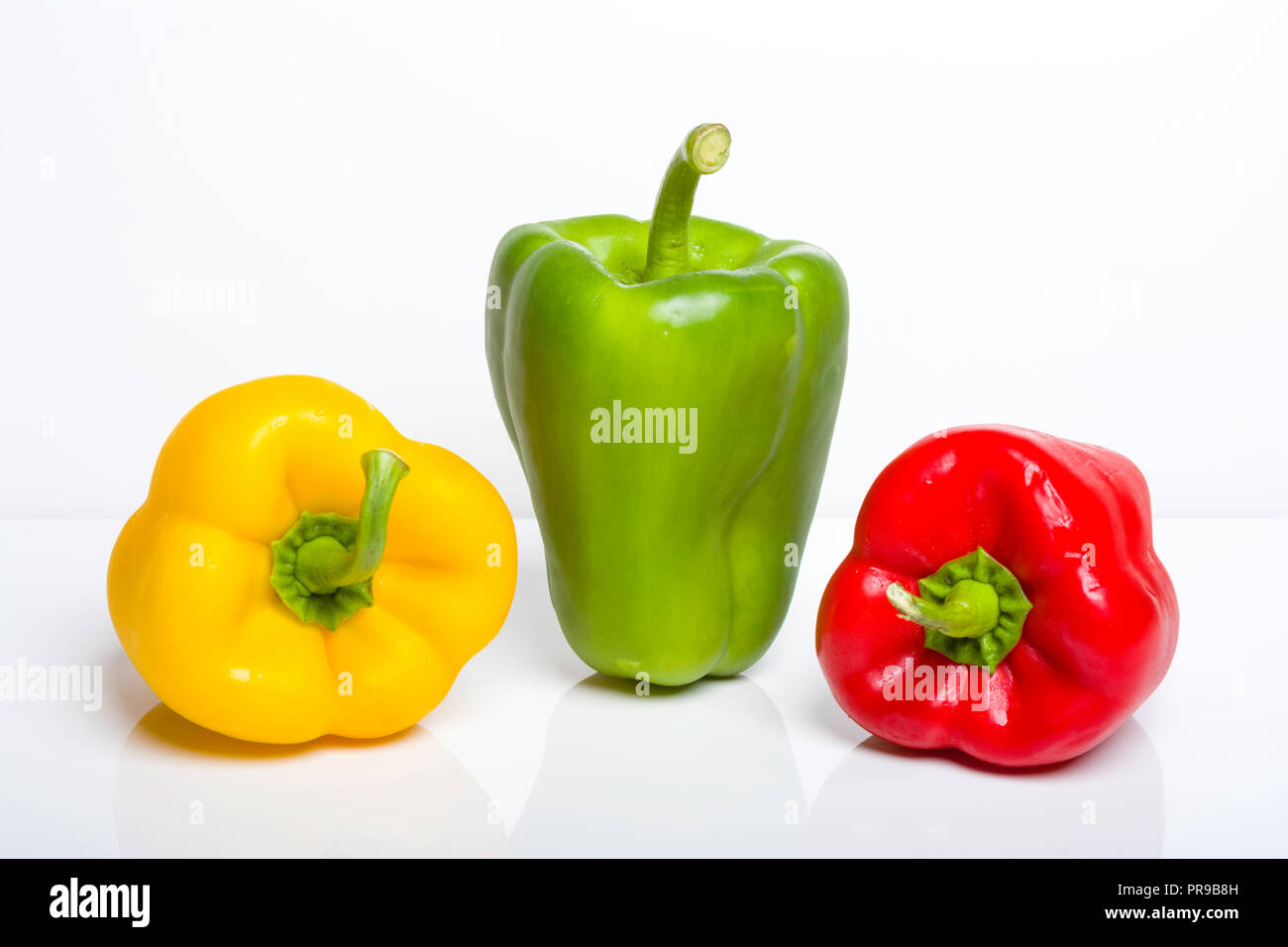 red, green and yellow bell peppers on a plain white background Stock ...
