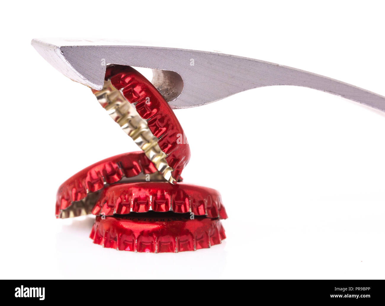 Bottle opener with red bottle tops on a white background Stock Photo