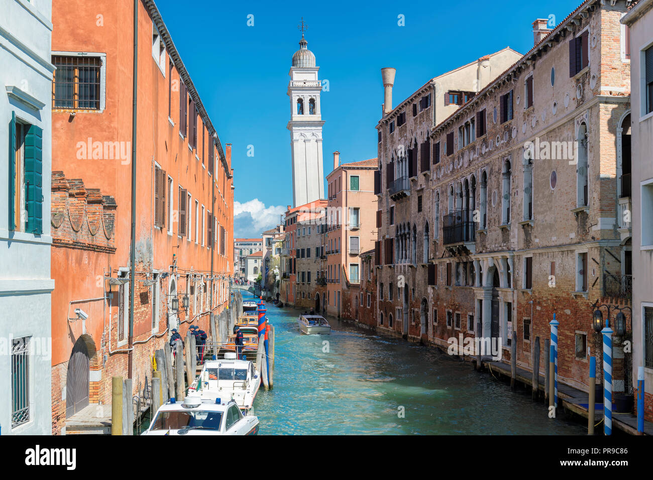 Old canal in Venice with boats parked near of residential buildings, Italy Stock Photo