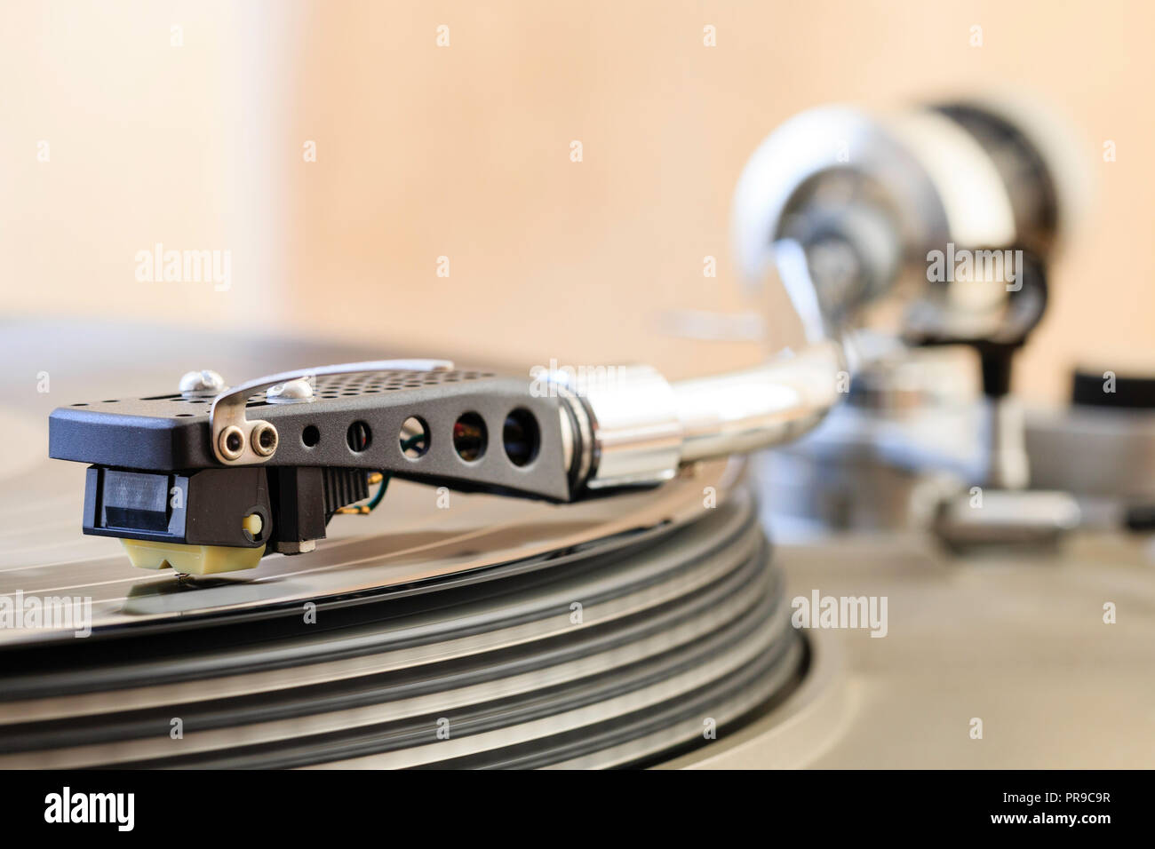 Record player, deck. 'S' shape tone arm playing long player record, LP, vinyl, also known as long playing record. Stock Photo