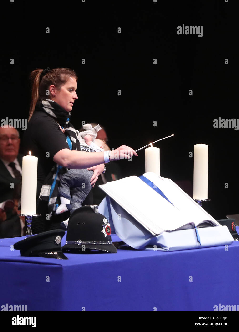 Samantha Dixon, wife of Constable James Dixon, lights a candle during the service at the Waterfront Hall, Belfast for National Police Memorial Day to honour police officers who have died or been killed in the line of duty. Stock Photo