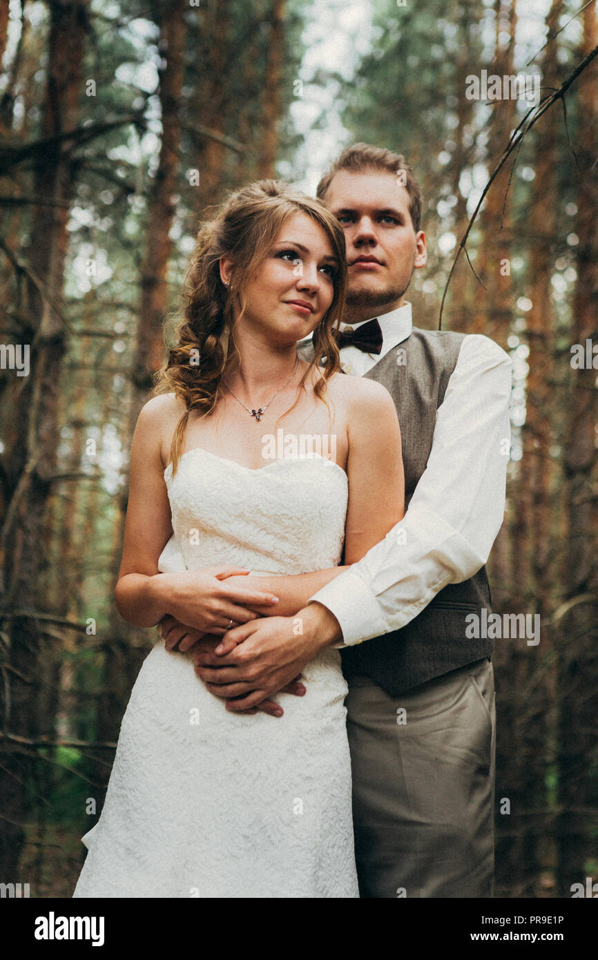bride and groom in the forest of firs Stock Photo - Alamy