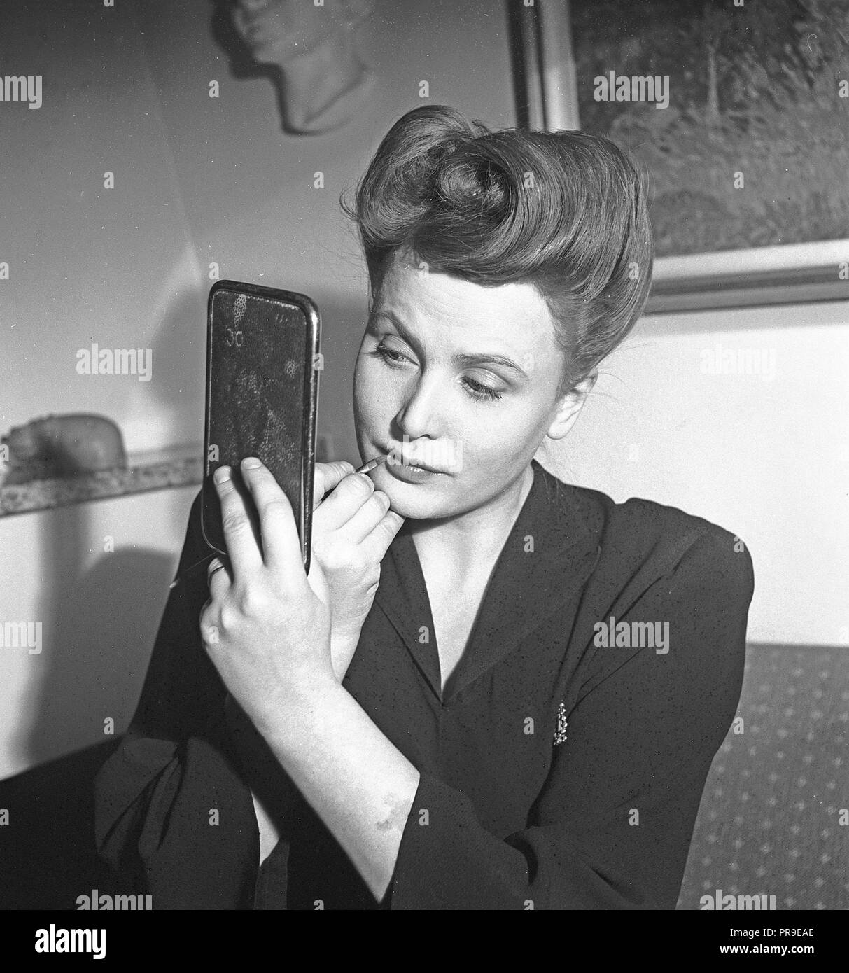 Swedish actress Birgit Tengroth , 1915-1983.  Pictured here when putting on her makeup. The hairstyle is typical 1940s.  Sweden 1944. Photo Kristoffersson ref G85-3 Stock Photo