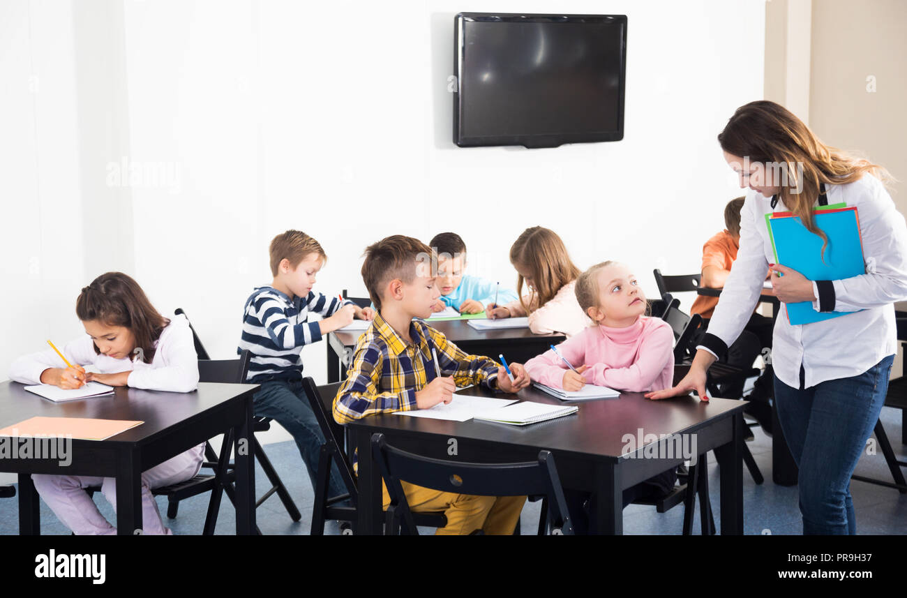 Happy little boys and girls with teacher drawing in classroom Stock ...