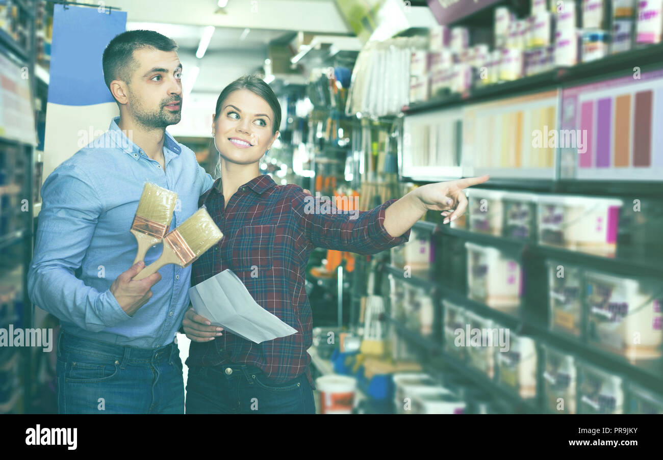 designer with shop list and brushes are looking modern color of paint