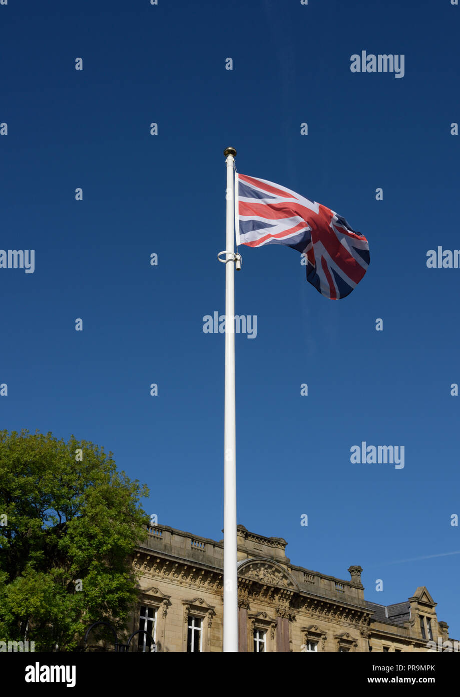 Union jack flag fluttering in the wind in a clear blue sky in bury ...