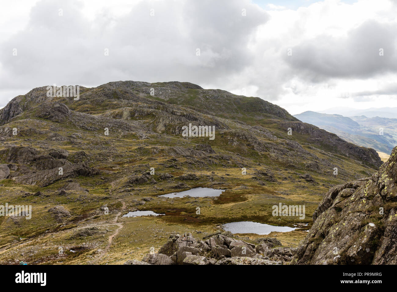 Three Tarns with Crinkle Crags beyond as viewed from Bowfell, Lake District, Cumbria, England. Stock Photo