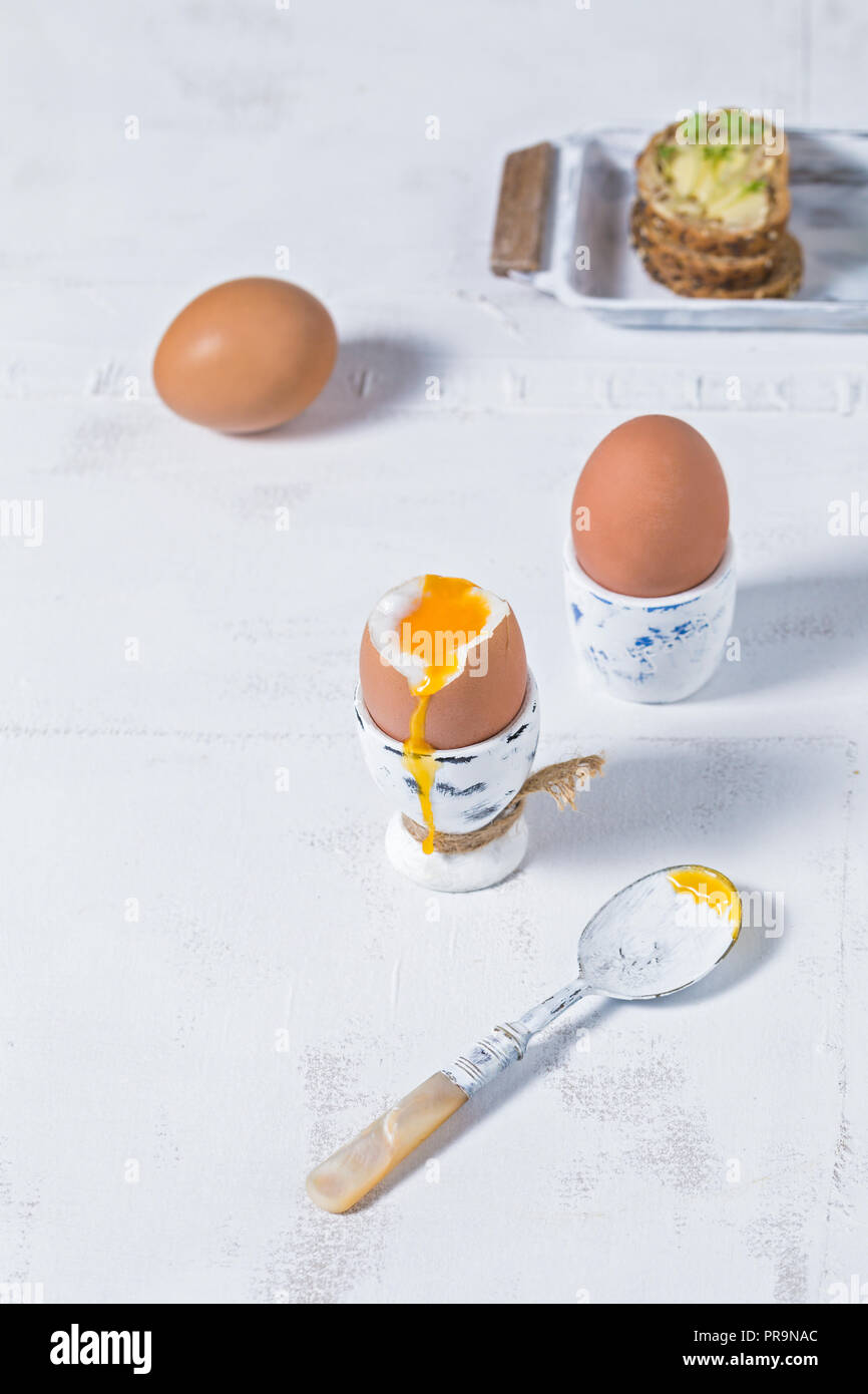 Soft boiled eggs breakfast on white rustic table top background Stock Photo