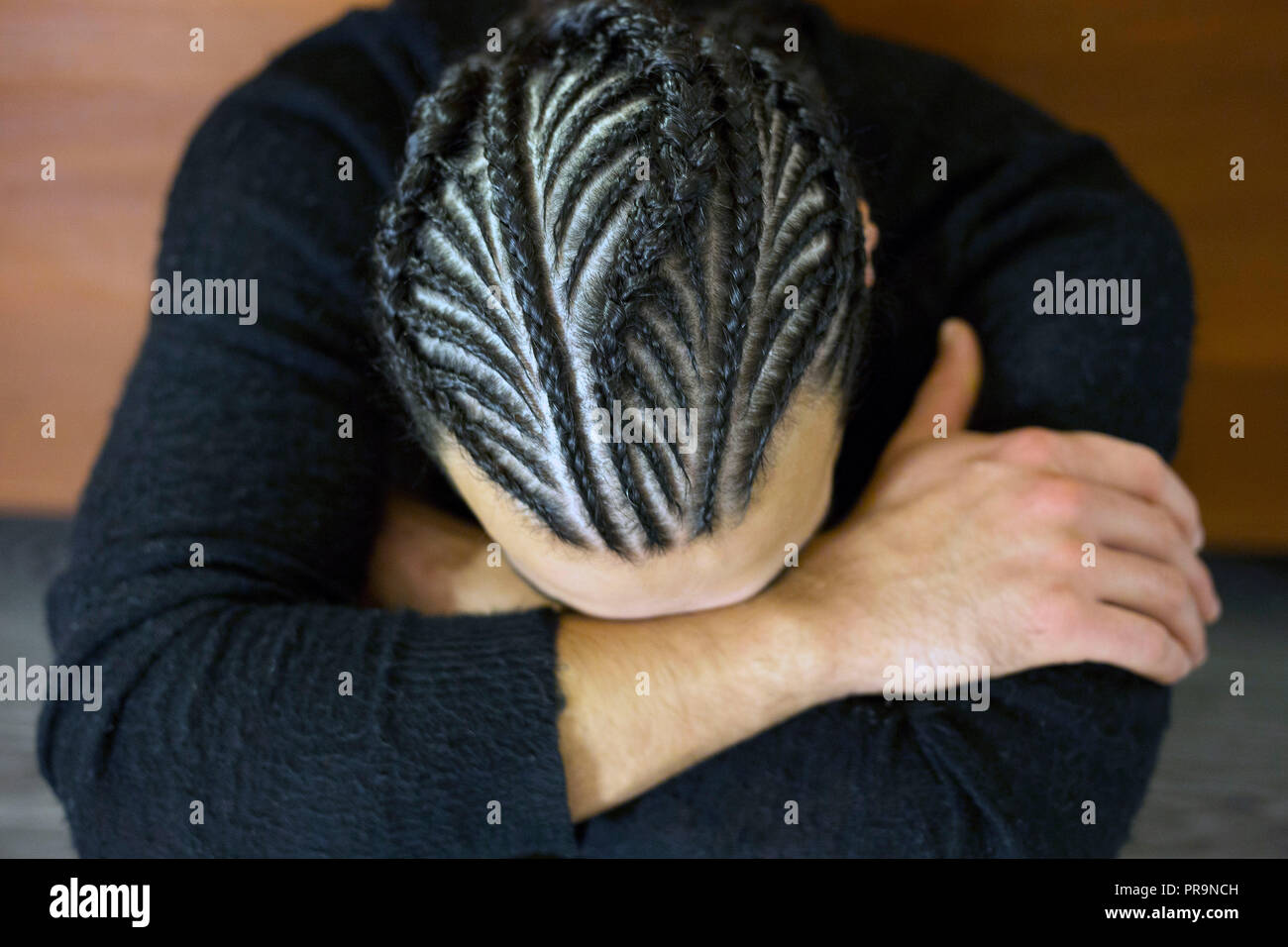 small braids on his head Man with face covered, dark hair, Schot Stock Photo