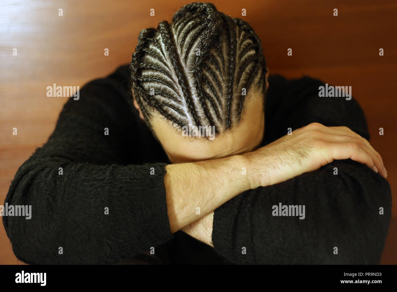 small braids on his head Man with face covered, dark hair, Schot Stock Photo