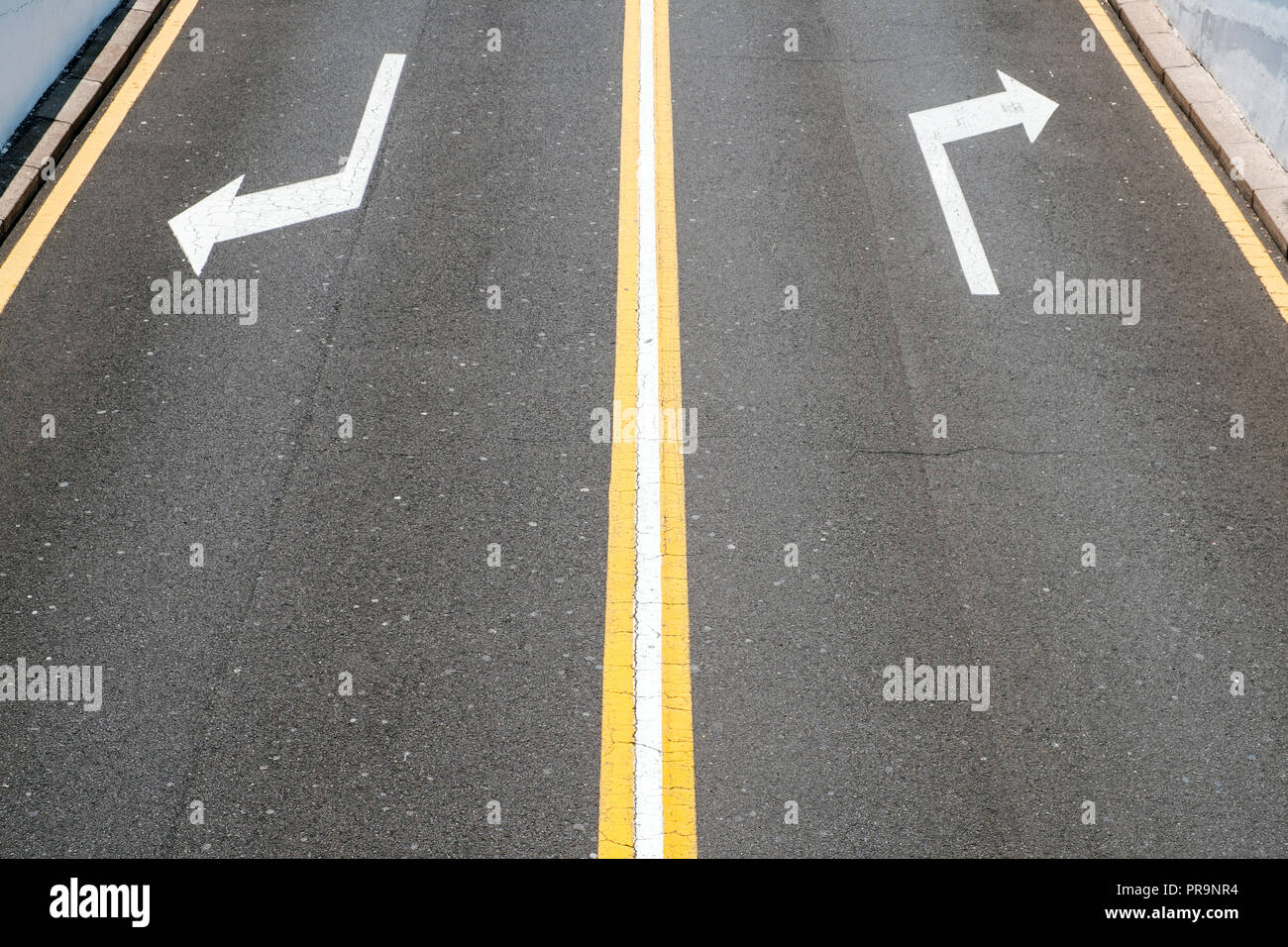left / right, direction arrows on asphalt road - Stock Photo