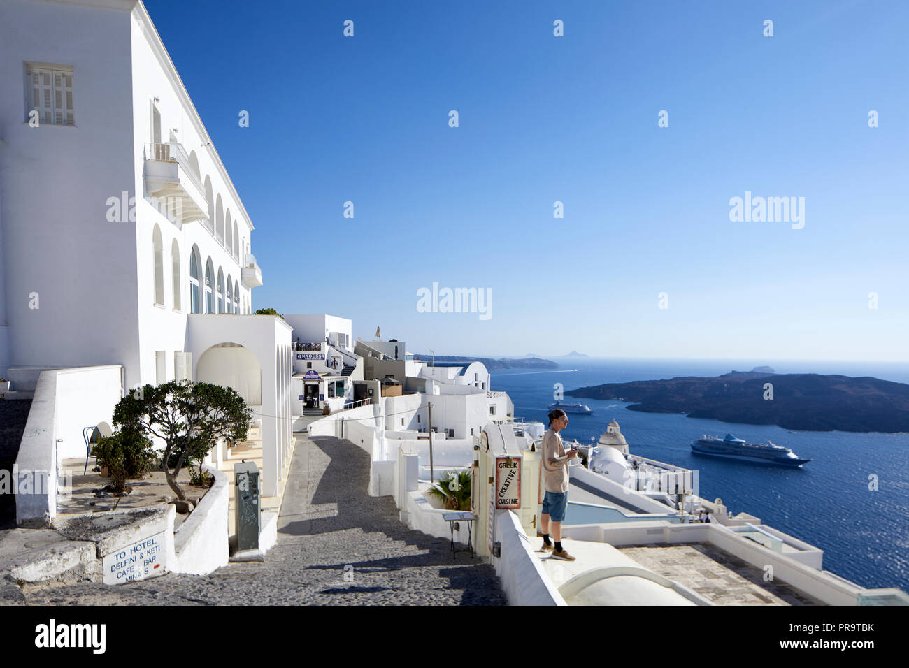 view from Aressana Spa Hotel and Suites Fira, Santorini, a Cyclades group of islands in Greece, tourists walking up the steep hill Stock Photo