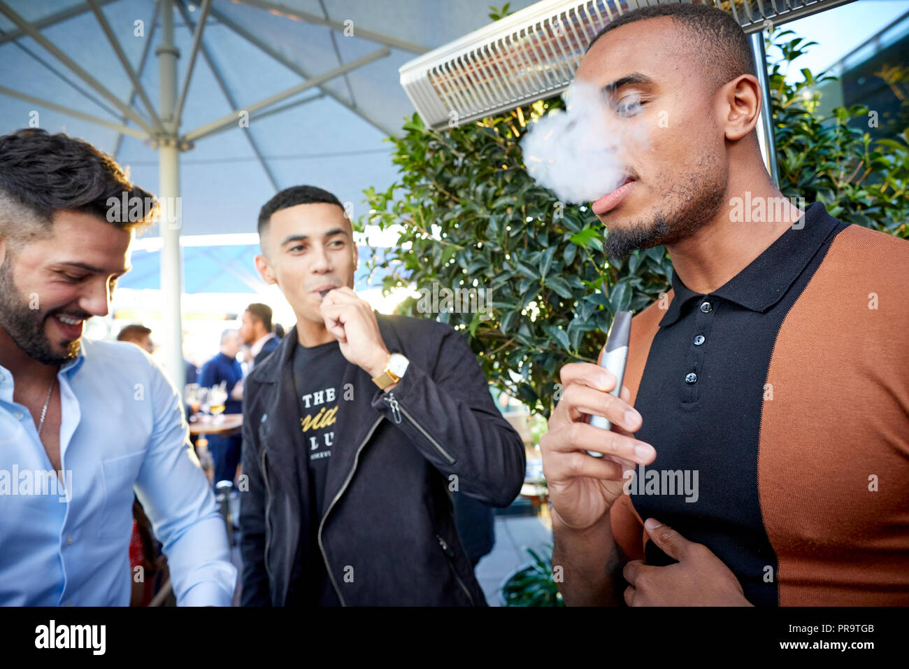 people smoking using vape happing pens in Manchester Stock Photo