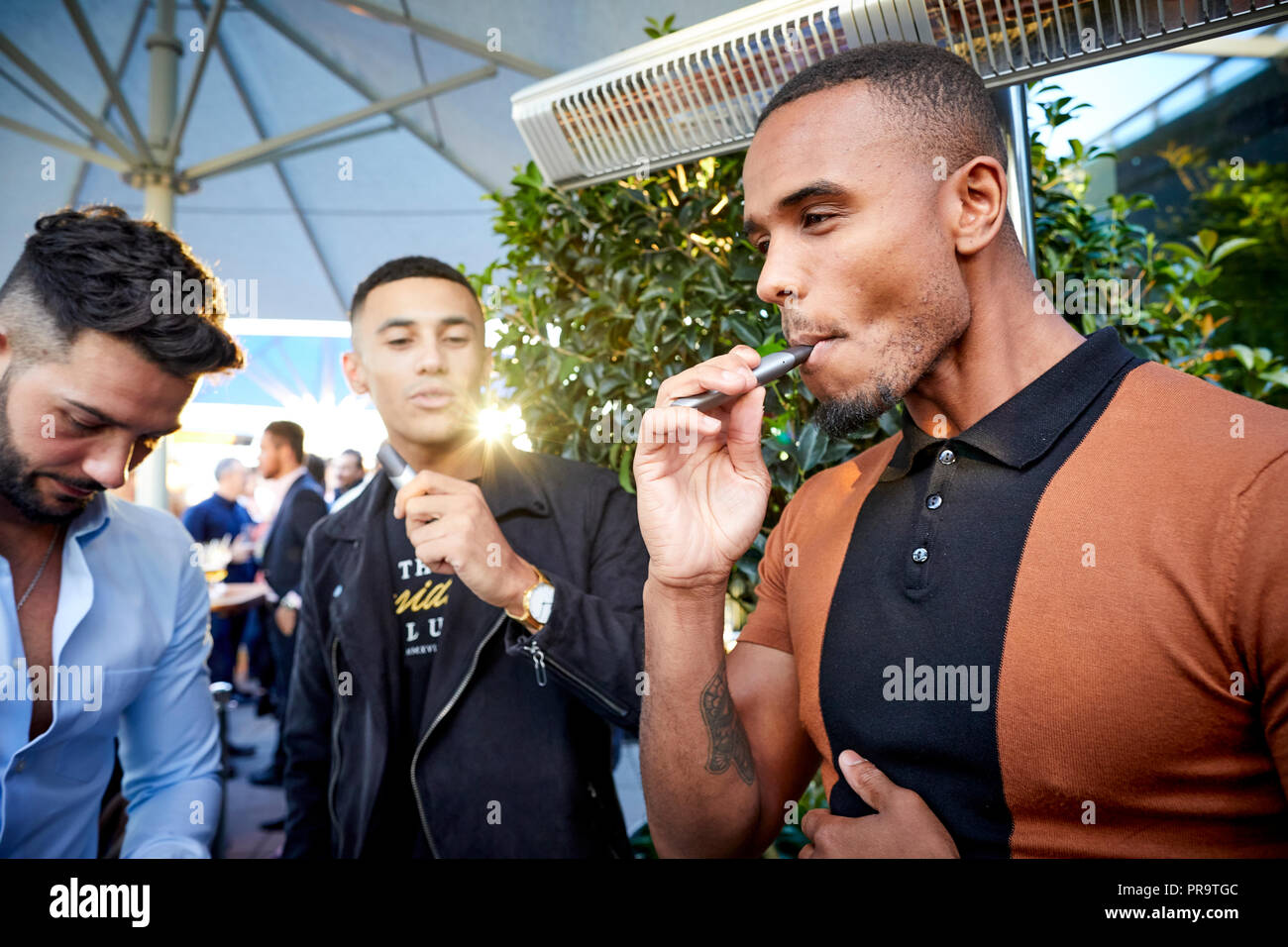 people smoking using vape happing pens in Manchester Stock Photo