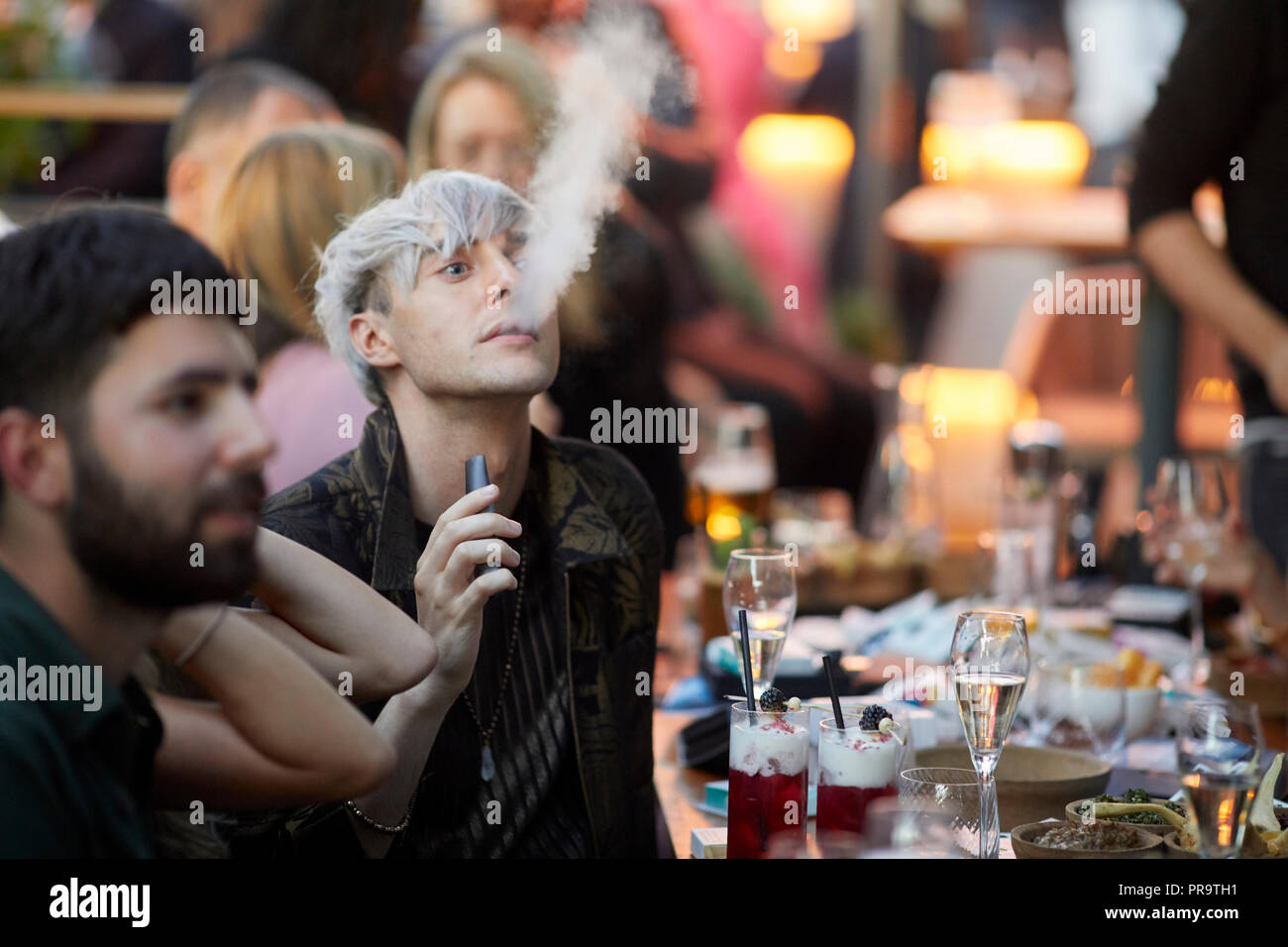 people smoking using vape happing pens in Manchester Stock Photo