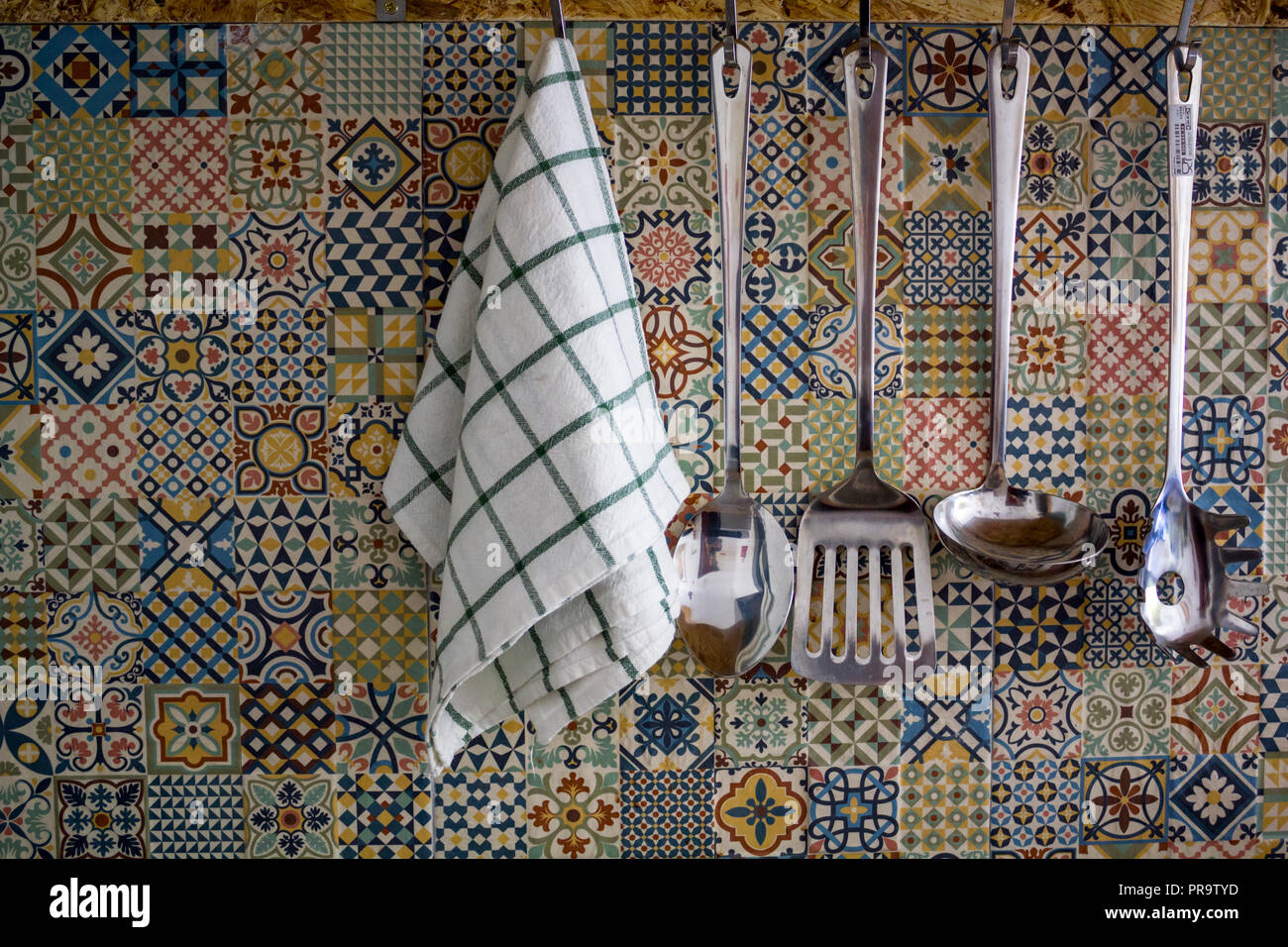 Kitchen utensils and Kitchen Towel hanging on kitchen wall Stock Photo