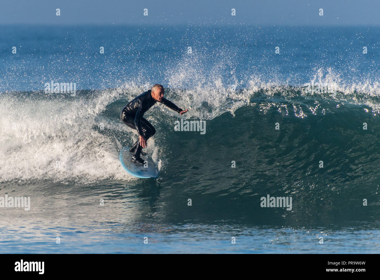 Baby Boomer male surfer dropping into a clean wave pushed by Hurricane Rosa at Ventura's Surfers Knoll on September 30, 2018 in California. Stock Photo