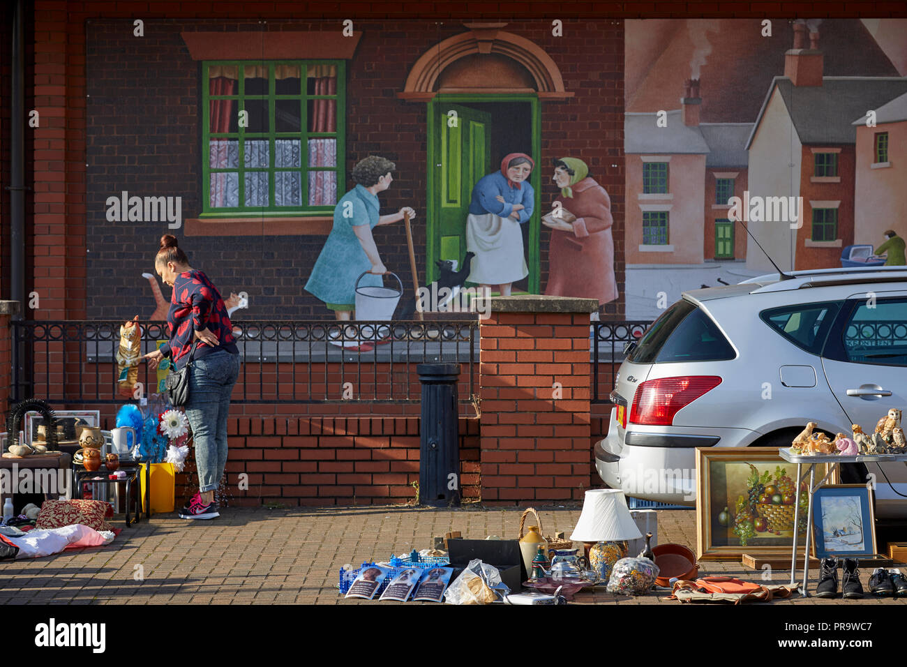 Car boot sale at the market hall with terraced house mural behind Stoke