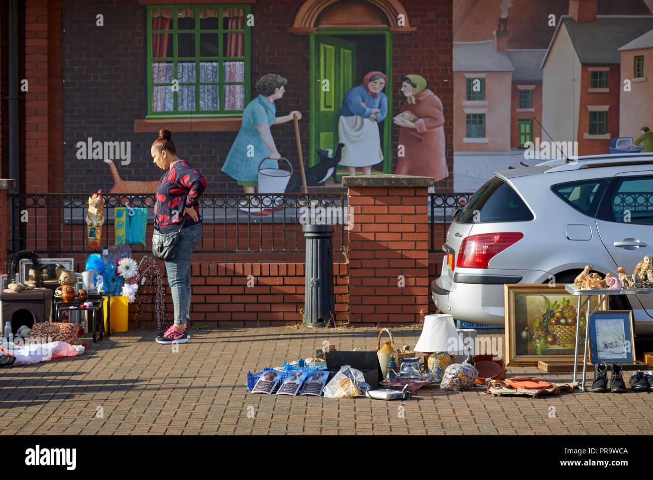 Car boot sale at the market hall with terraced house mural behind Stoke