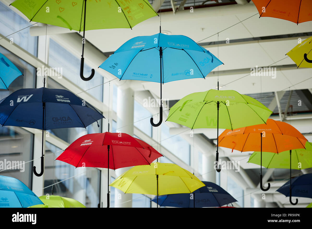 Brightly coloured umbrellas suspended in MediaCityUK Salford Quays to raise awareness of Attention Deficit Hyperactivity Disorder (ADHD) and autism Stock Photo