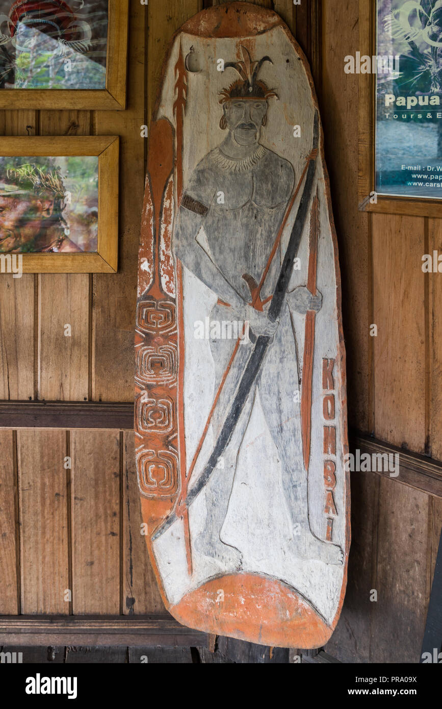A wooden war shield with beautiful painting of native tribesman figure. Wamena, Papua, Indonesia. Stock Photo