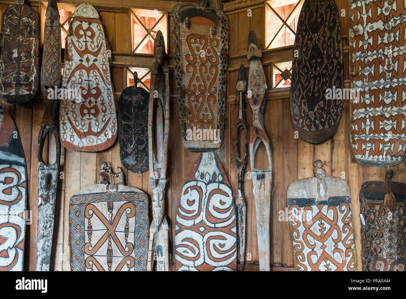 A collection of native war shield hanging on a wall. Wamena, Papua, Indonesia. Stock Photo