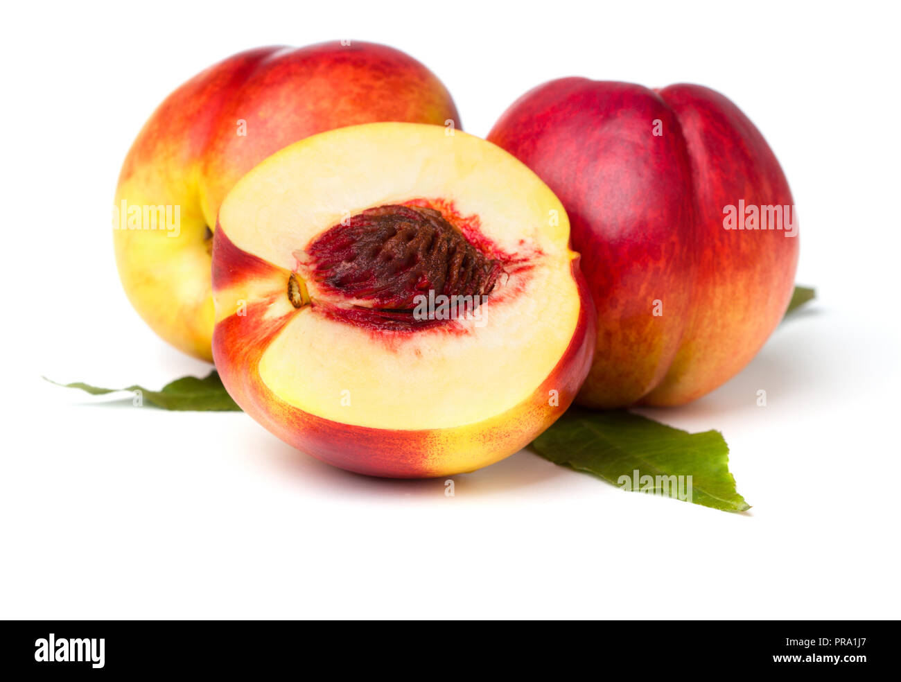 three nectarines with leaves isolated on white background Stock Photo