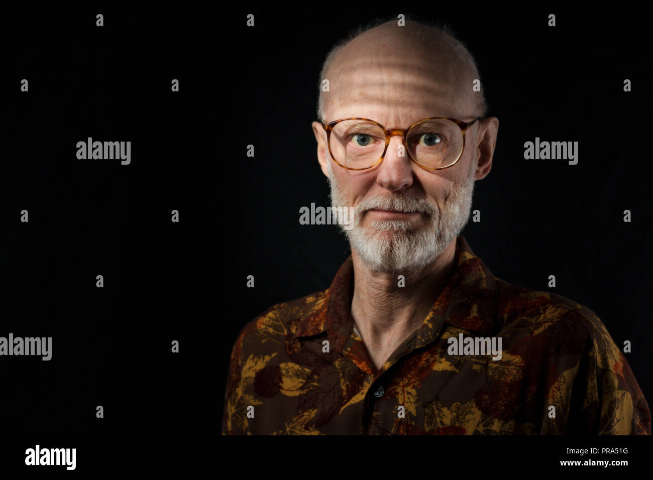 portrait of senior man in casual brown shirt on black background Stock Photo