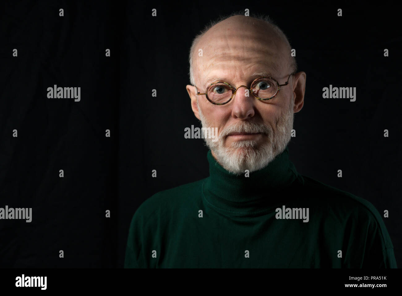 portrait of adult man with glasses on black background Stock Photo