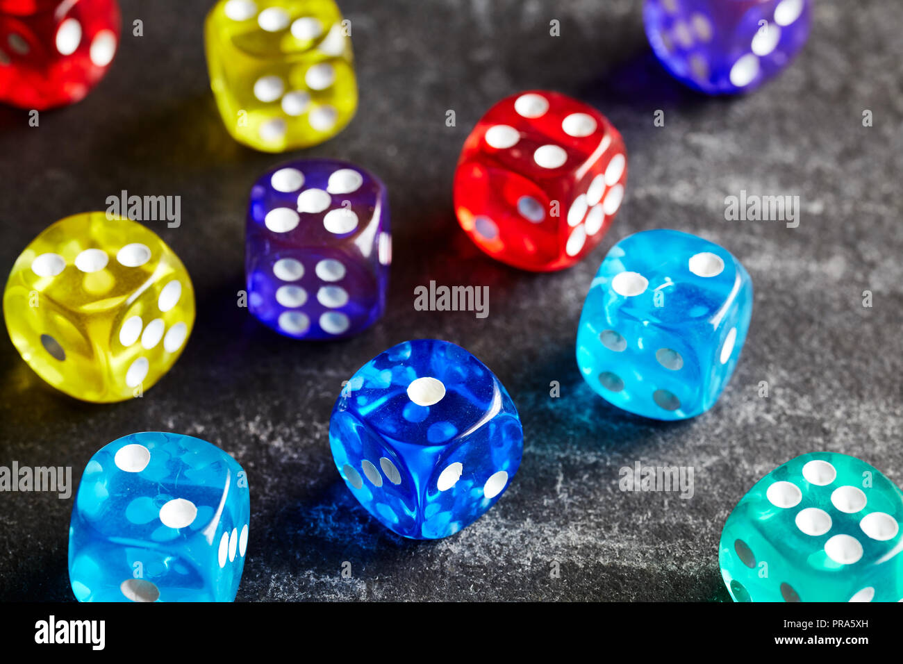 Colorful dice on a dark background, selective focus. Stock Photo