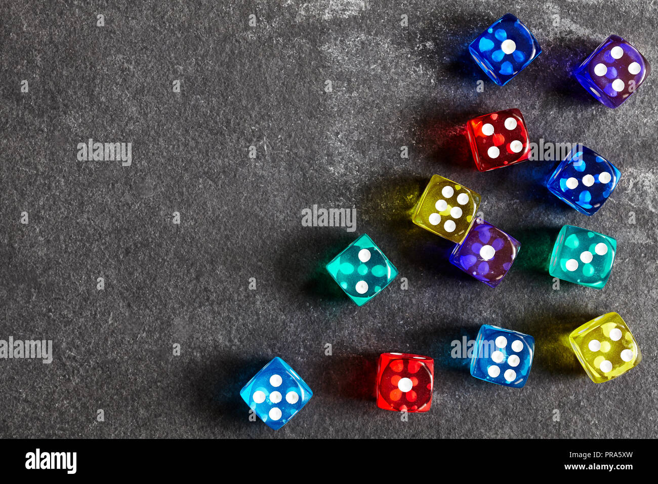 Colorful dice on a dark background, selective focus, space for text. Stock Photo