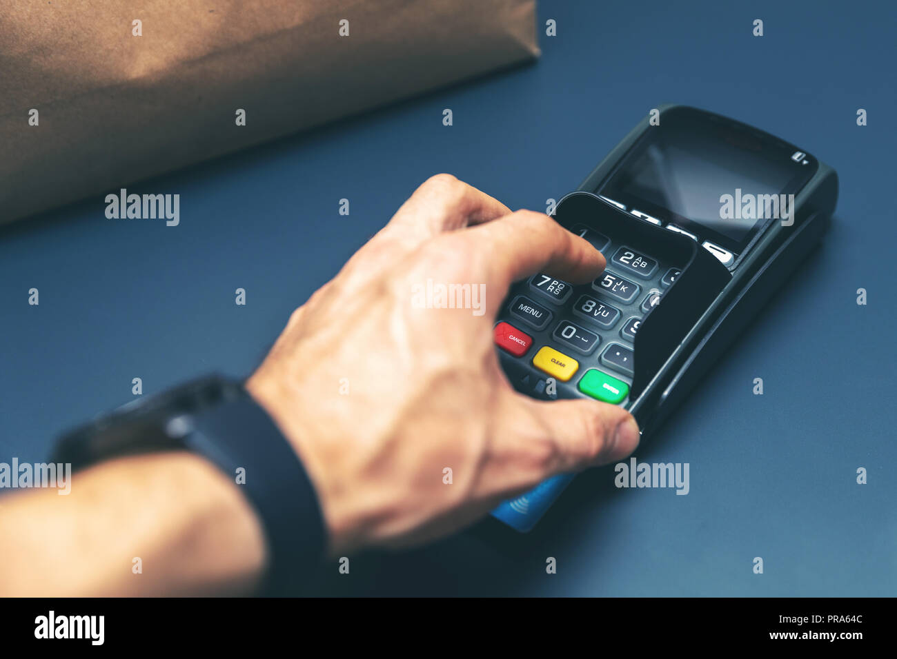 credit card purchase at store hand entering pin code Stock Photo