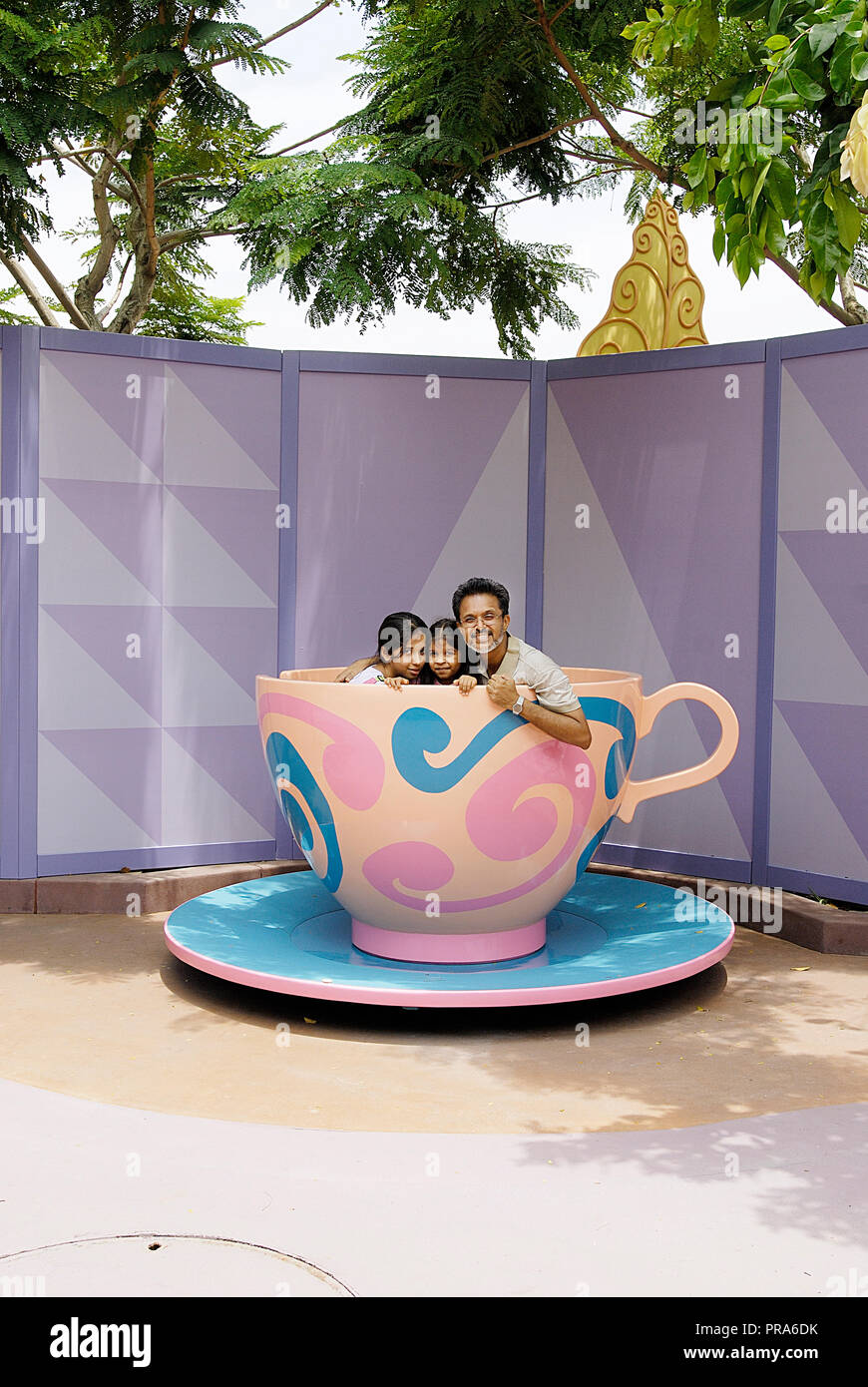 PORTRAIT OF A FATHER AND TWO DAUGHTERS INSIDE THE OF MAD HATTER'S TEA
