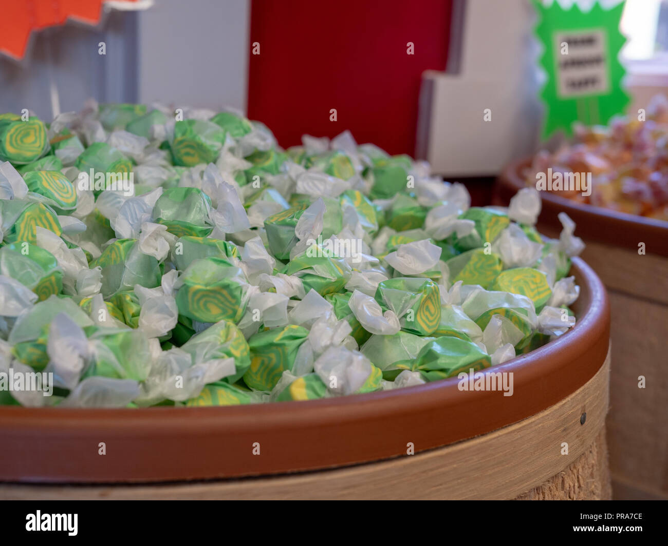 Lemon line taffy candy piled in barrel displayed in store Stock Photo