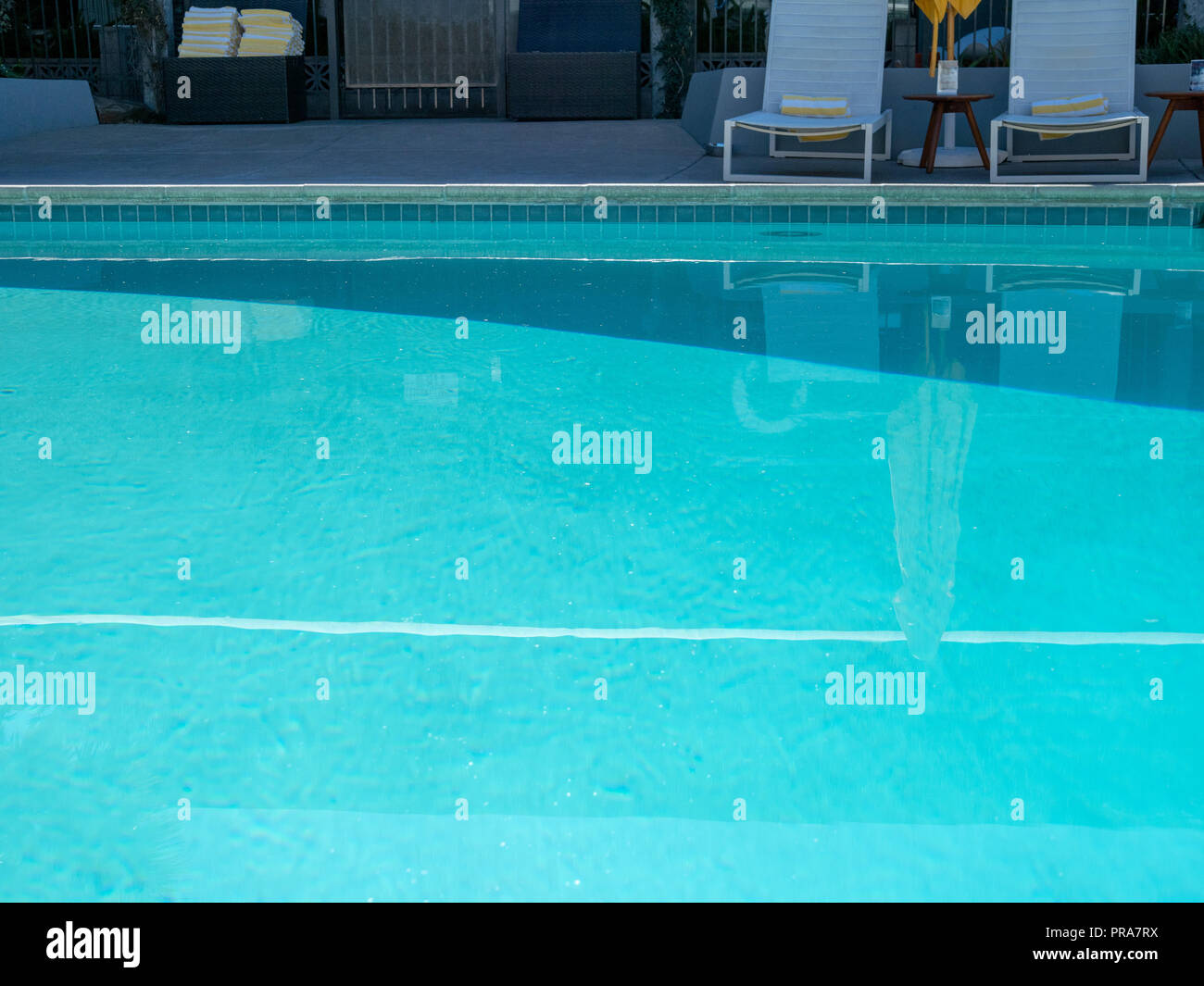 Pool and lounge chairs at a sunny resort Stock Photo - Alamy