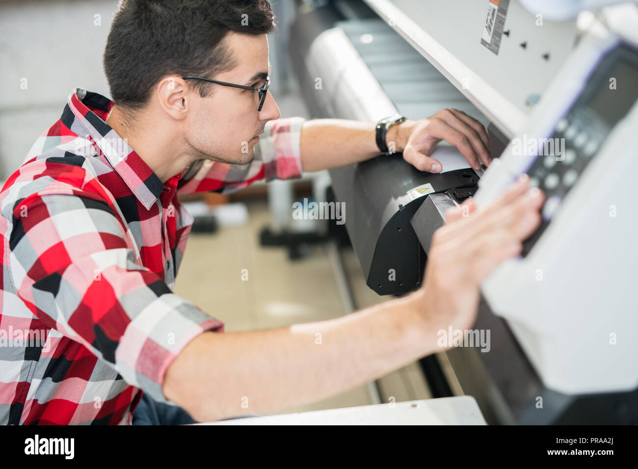 Engineer examining wide format printer Stock Photo