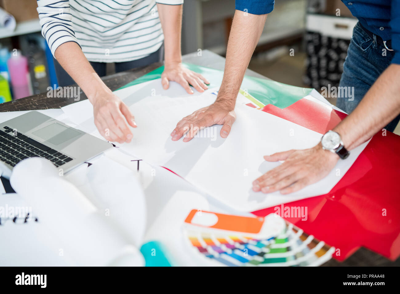 Colleagues of printing house touching paper Stock Photo