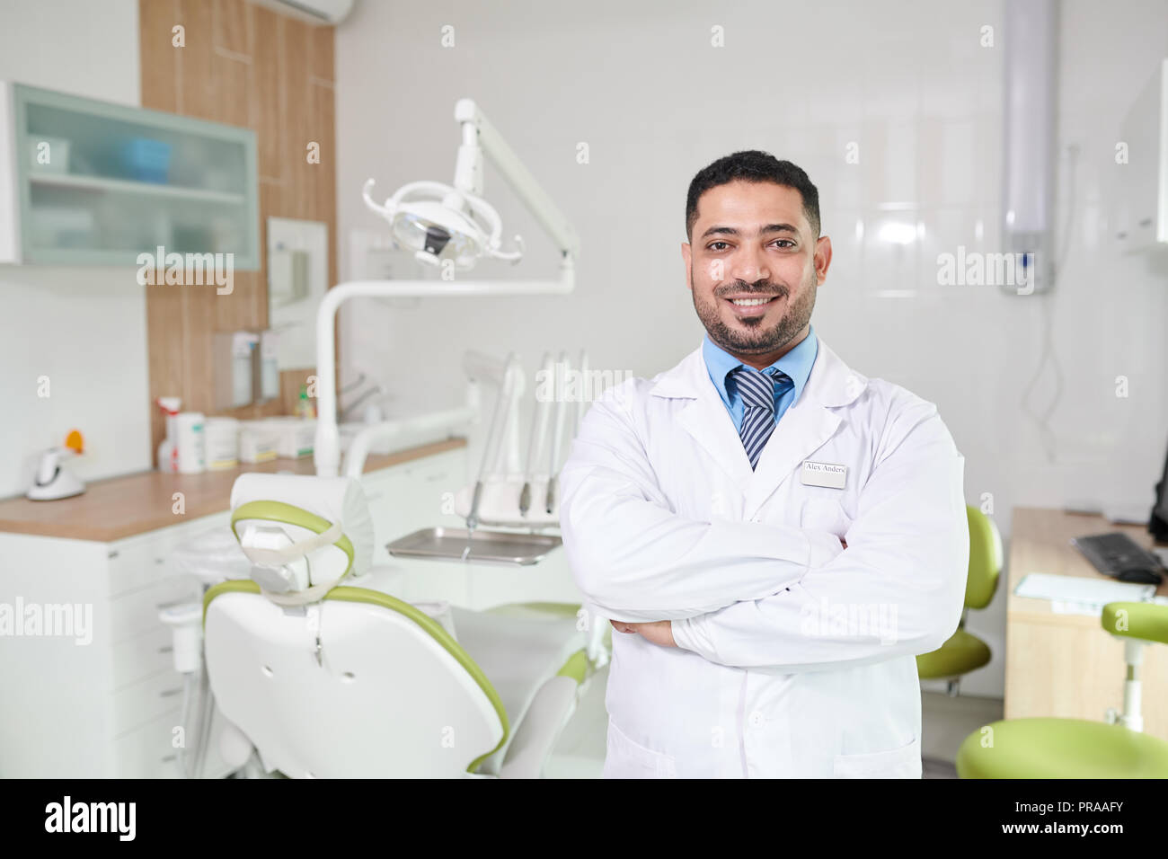 Middle-Eastern Dentist Posing at Workplace Stock Photo