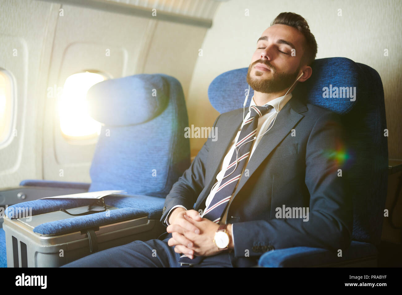 Handsome Businessman Sleeping in Plane Stock Photo