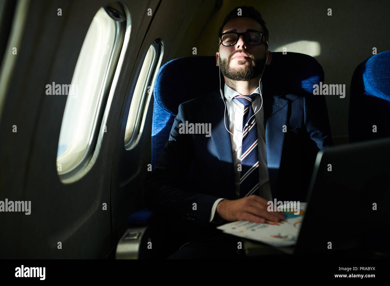 Businessman Sleeping in Flight Stock Photo