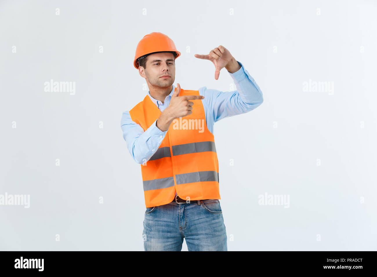 Young handsome architec man with wearing safety helmet over isolated background making frame with hands and fingers with happy face. Creativity and photography concept. Stock Photo