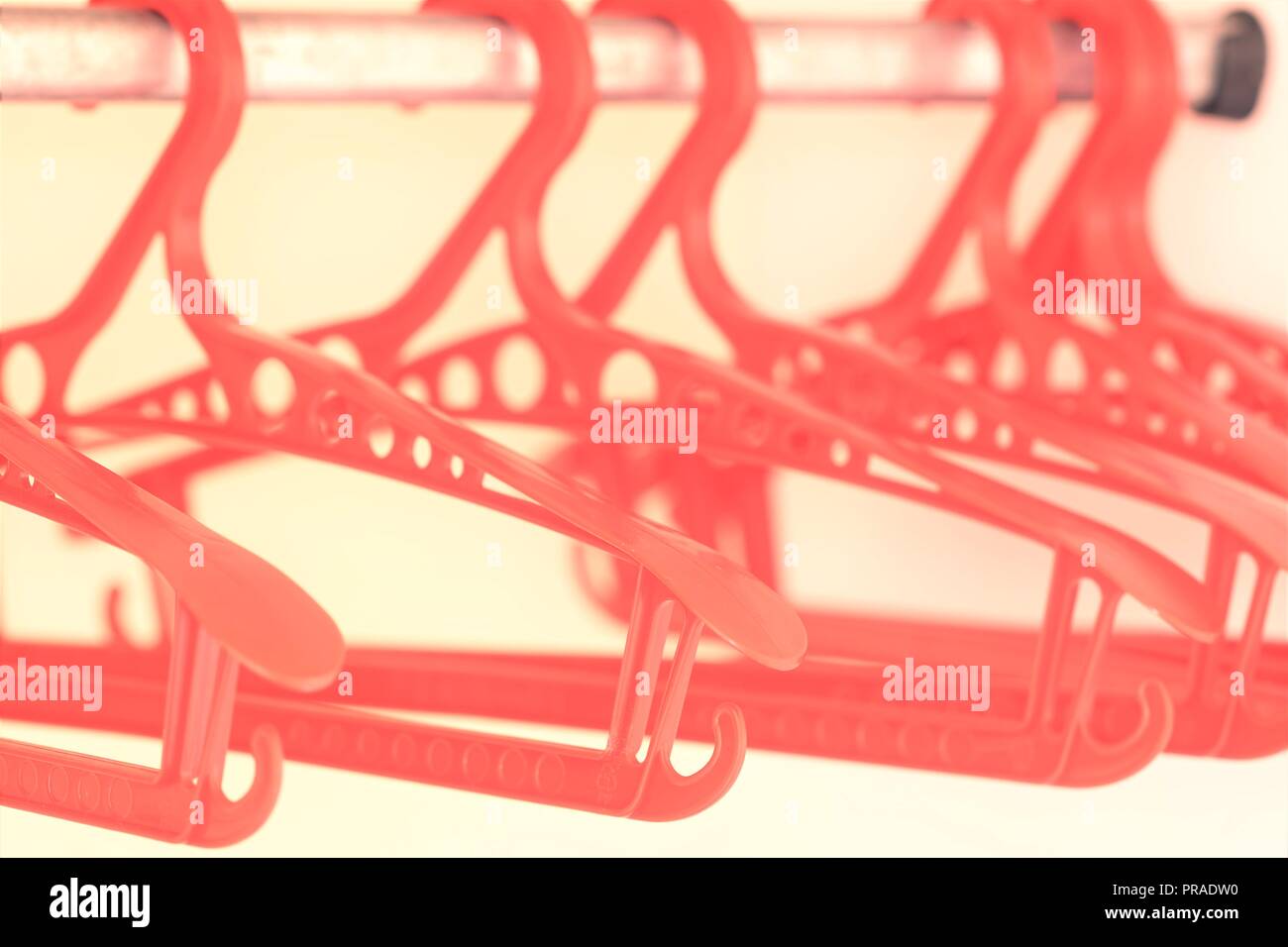 Red plastic hangers in an empty wardrobe Stock Photo