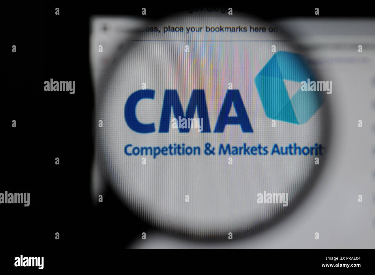 The Competition and Markets Authority (CMA) website seen through a magnifying glass Stock Photo