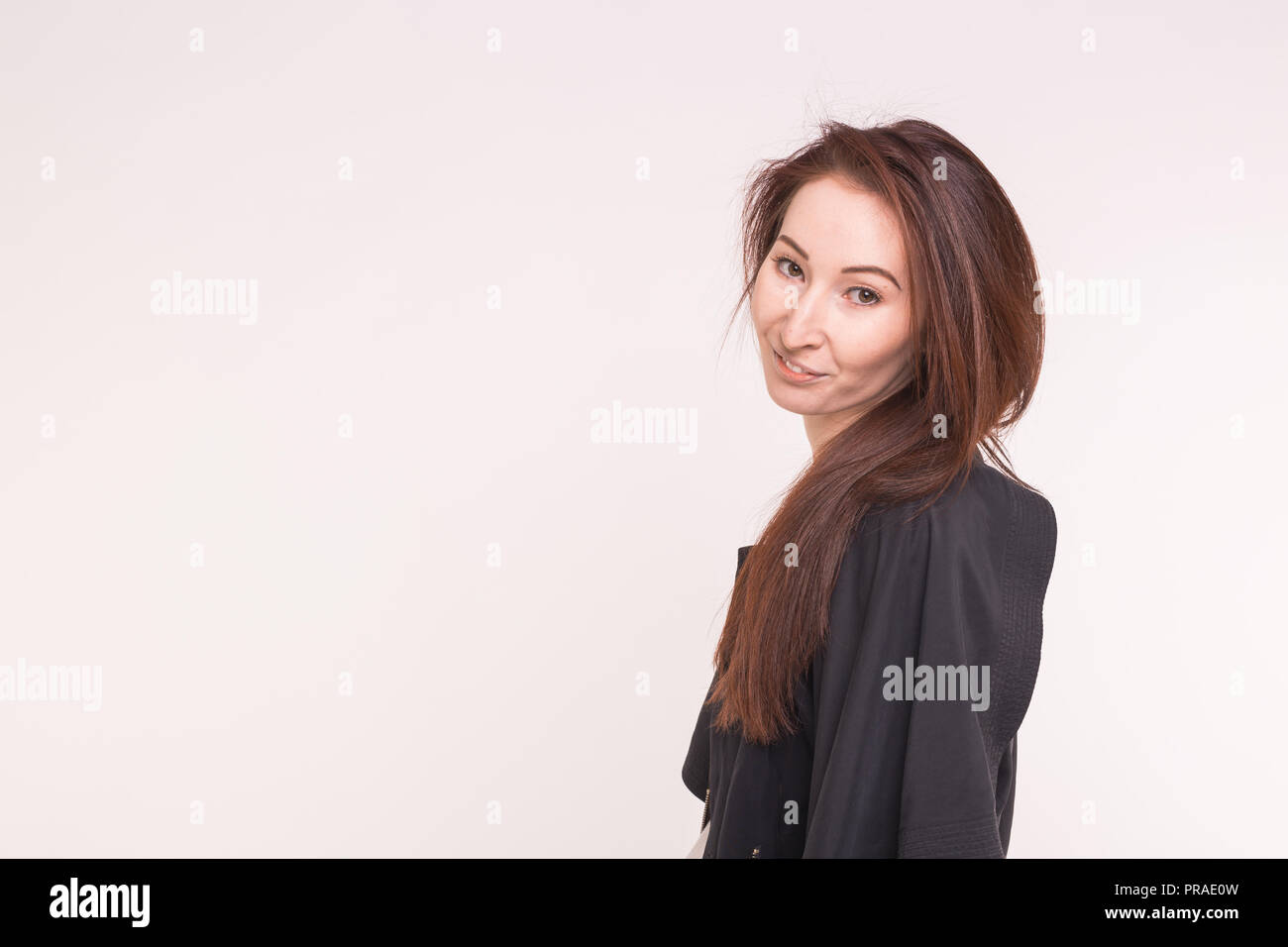 Young asian woman in black coat on white background with copy space ...