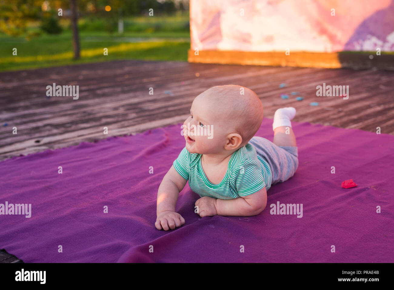 Cute child baby boy lying on blanket in summer day on nature. Family