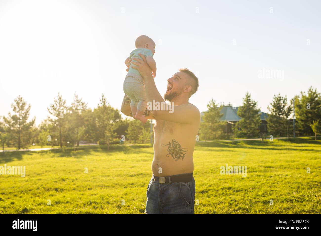 Happy father holding baby son, throwing baby in air. Concept of happy