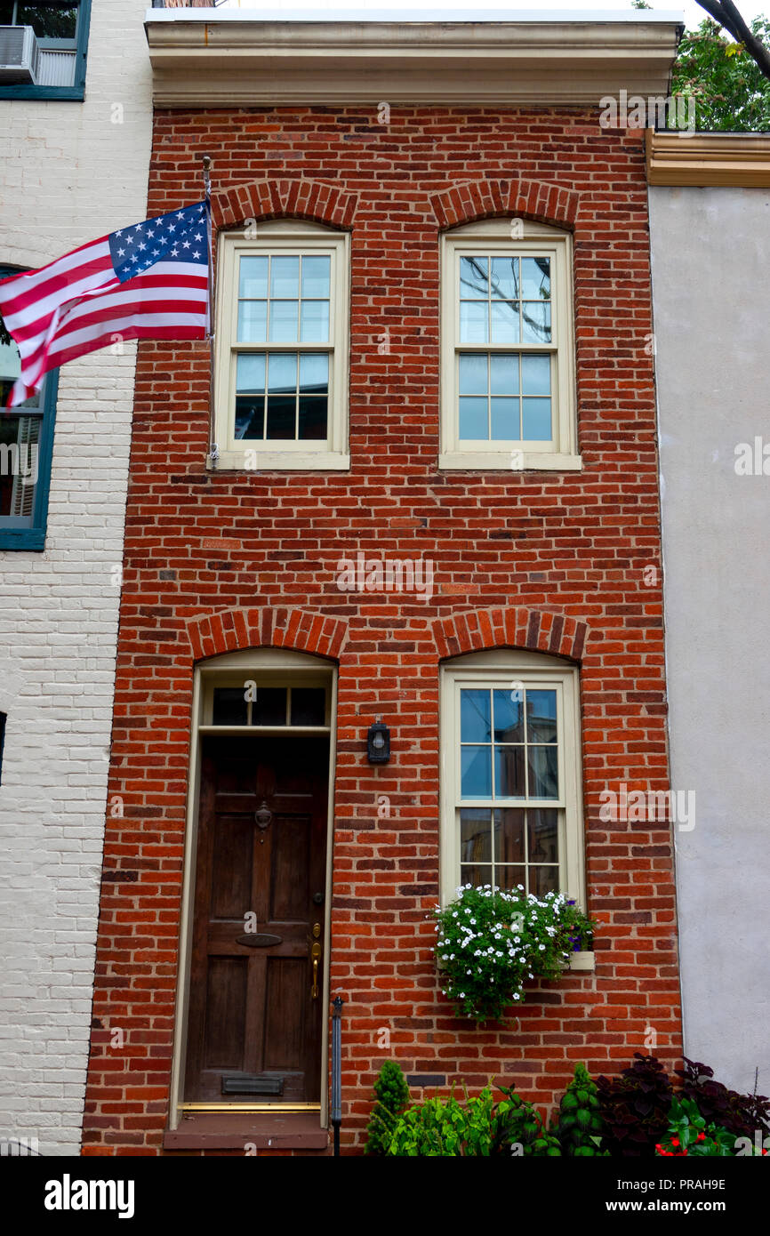 USA Maryland MD Fells Point Baltimore Exterior of a old brick narrow rowhouse with American flag Stock Photo