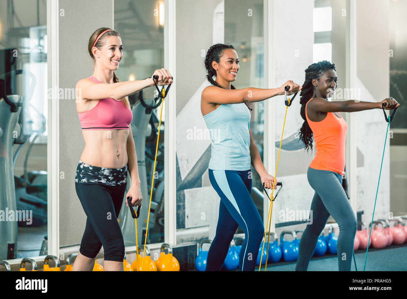 Full length of three fit women exercising with resistance bands  Stock Photo