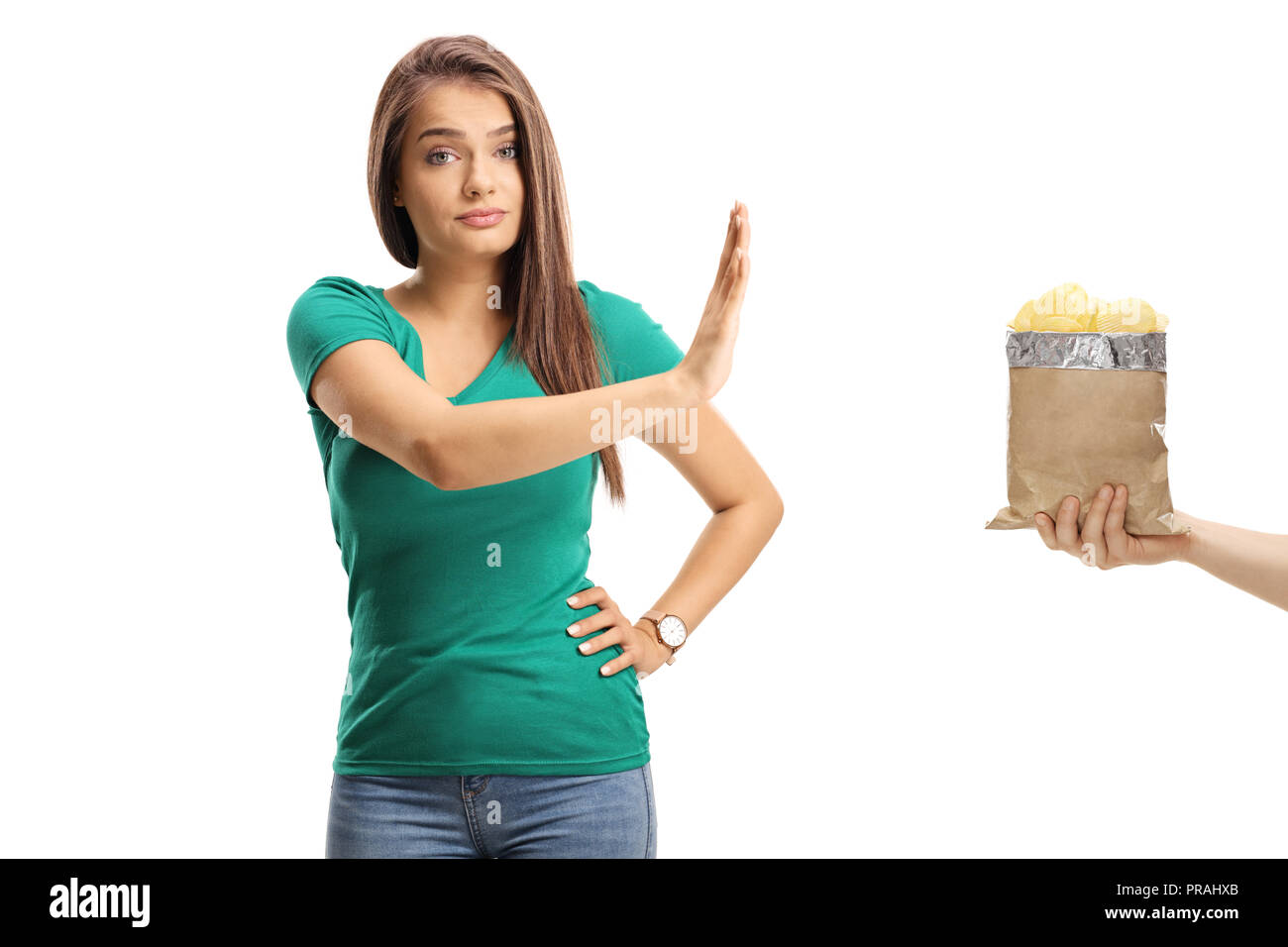 Beautiful young female gesturing refusal with her hand to a packet of crisps isolated on white background Stock Photo